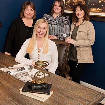 Four Interior Design Students posing at a desk