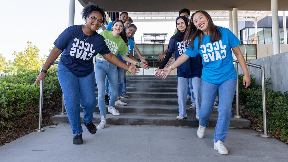 Students on steps with welcome arms.